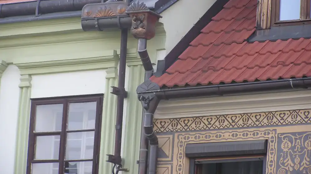 A built-in box gutter running along the roofline of an older brick building