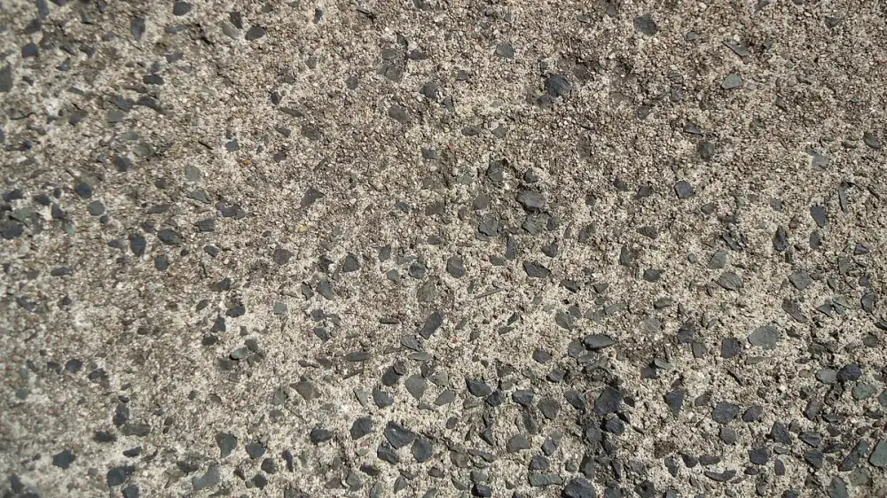 A gray concrete driveway and walkway with light surface staining