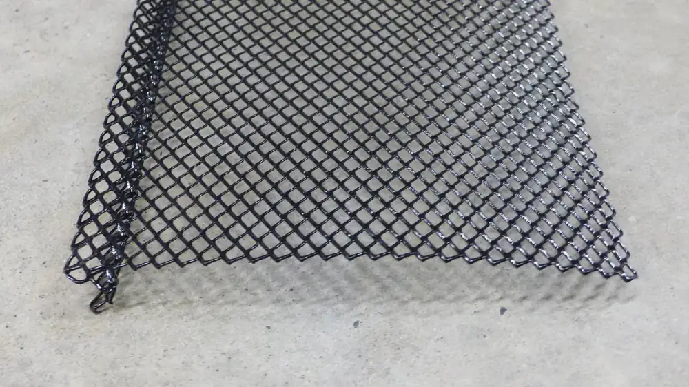 Debris resting on top of a mesh gutter guard along a home's roof edge