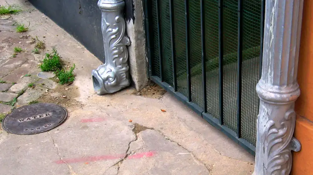 A downspout carrying water from a gutter outlet down to an extension on the ground