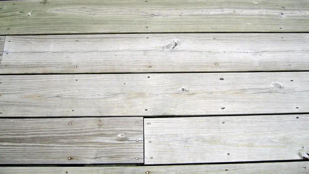 Composite deck boards being cleaned with a soft brush
