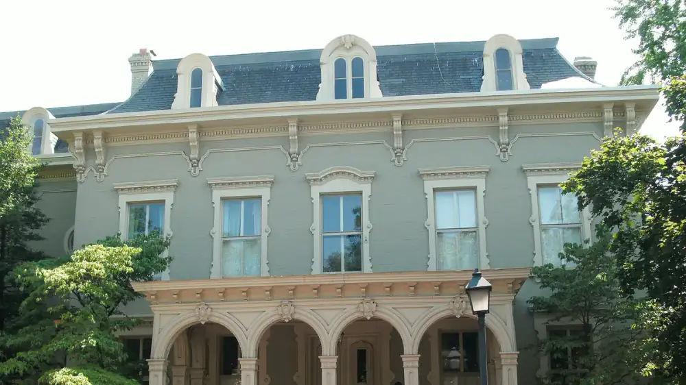 Covered front porch with columns, a painted ceiling and a swept floor