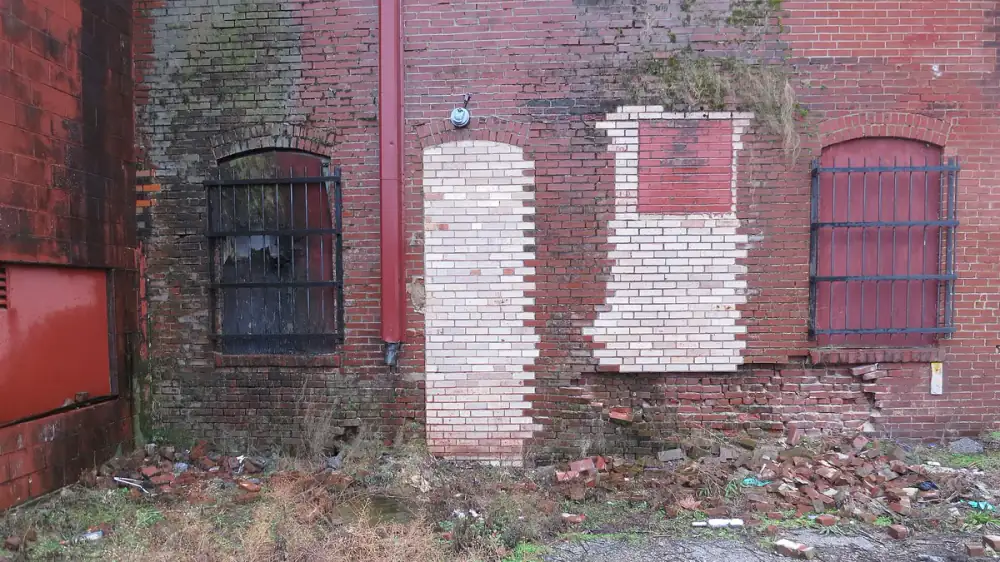 Rainwater running down a home's exterior wall and pooling at the foundation