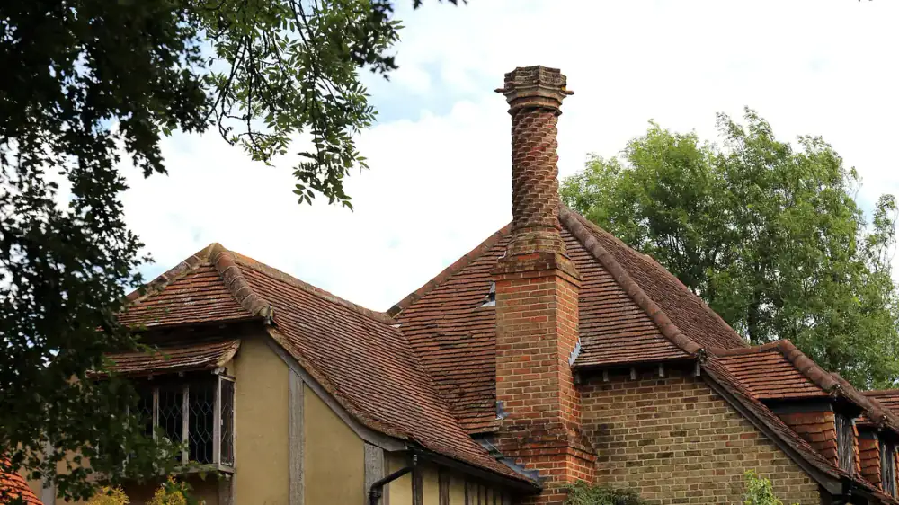 Diagram-style view of a brick chimney showing cap, crown, and flashing