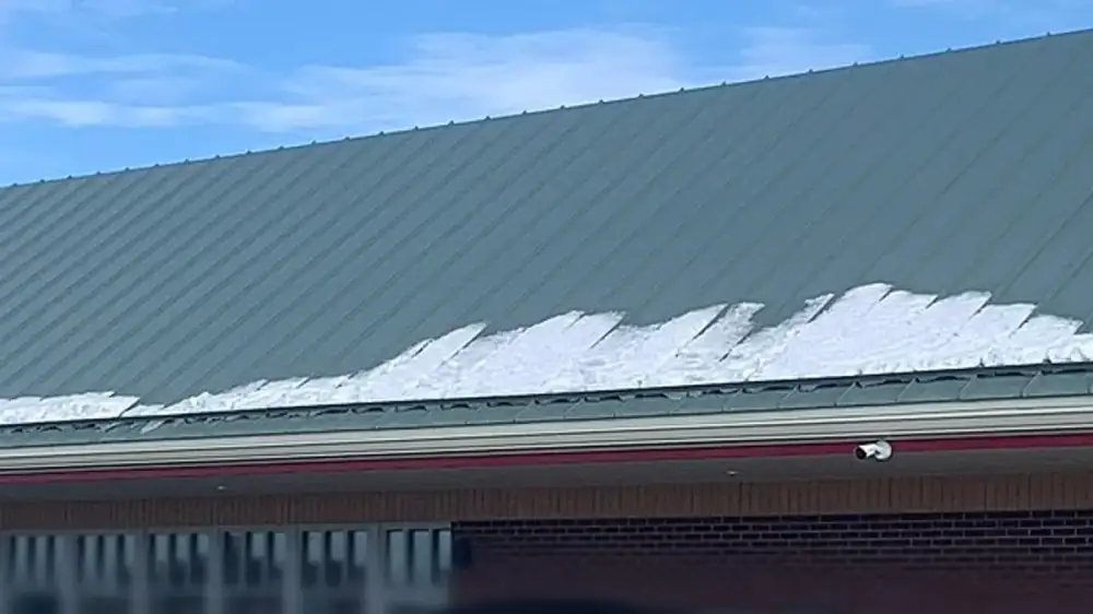 Metal drip edge installed along a roof edge above a gutter and fascia board