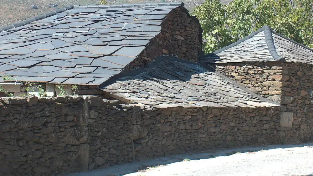 Gray natural slate roof tiles arranged in overlapping courses on a steep roof