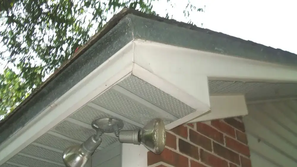 Vinyl soffit panel sagging and pulling loose from the underside of a roof eave