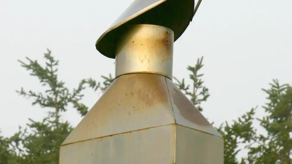 Several styles of metal chimney caps shown on masonry chimney tops