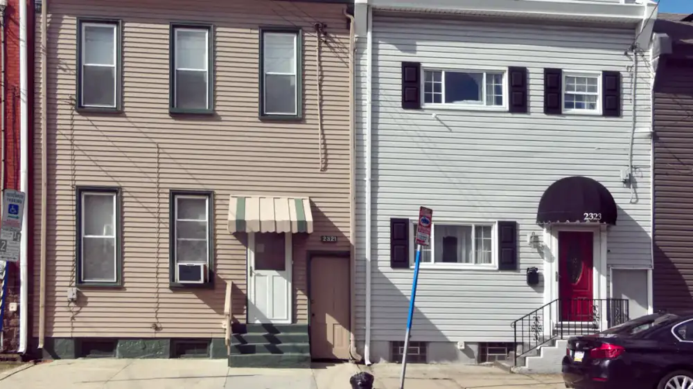 Rows of light-colored horizontal vinyl siding panels on a house exterior