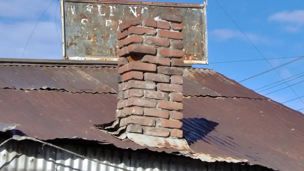 An old capped brick chimney on a house with no active fireplace