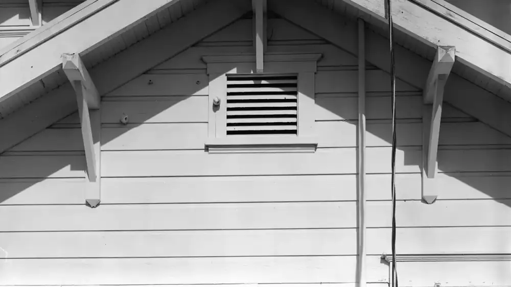 Open eave with exposed wooden rafter tails and no soffit under the overhang
