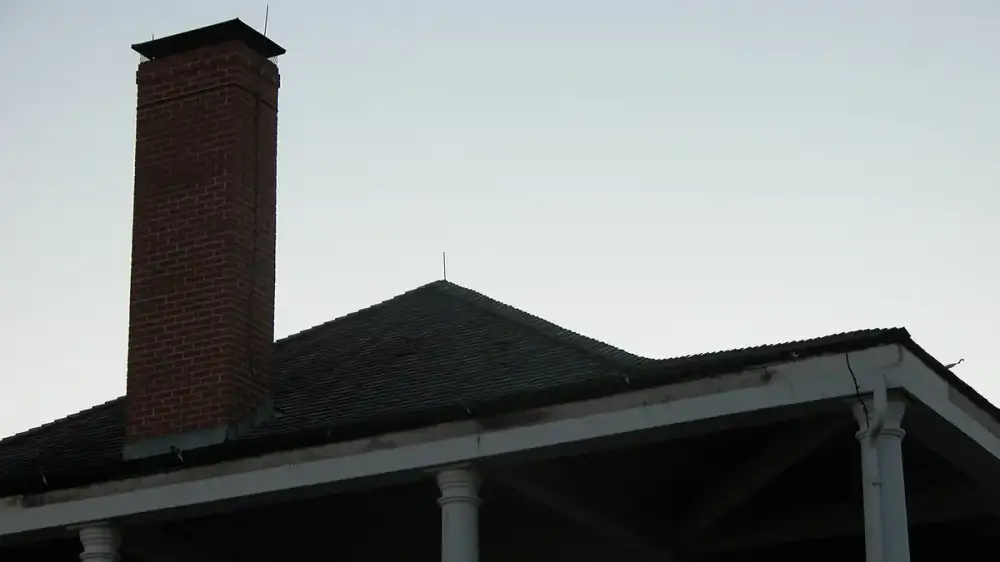 Water stains on fascia board behind a roof-edge gutter