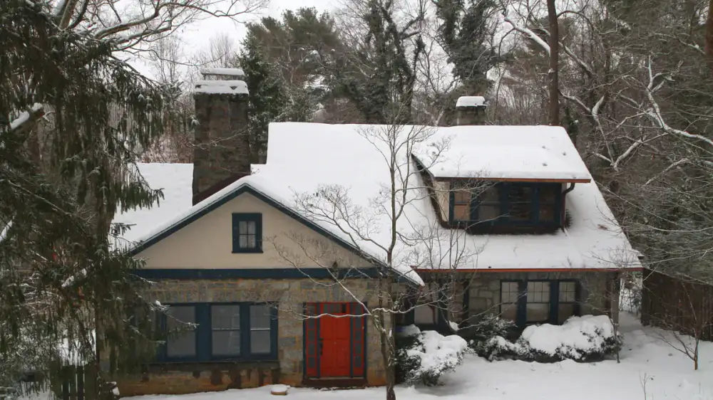 Icicles and snow along a home's roof edge and gutters in winter